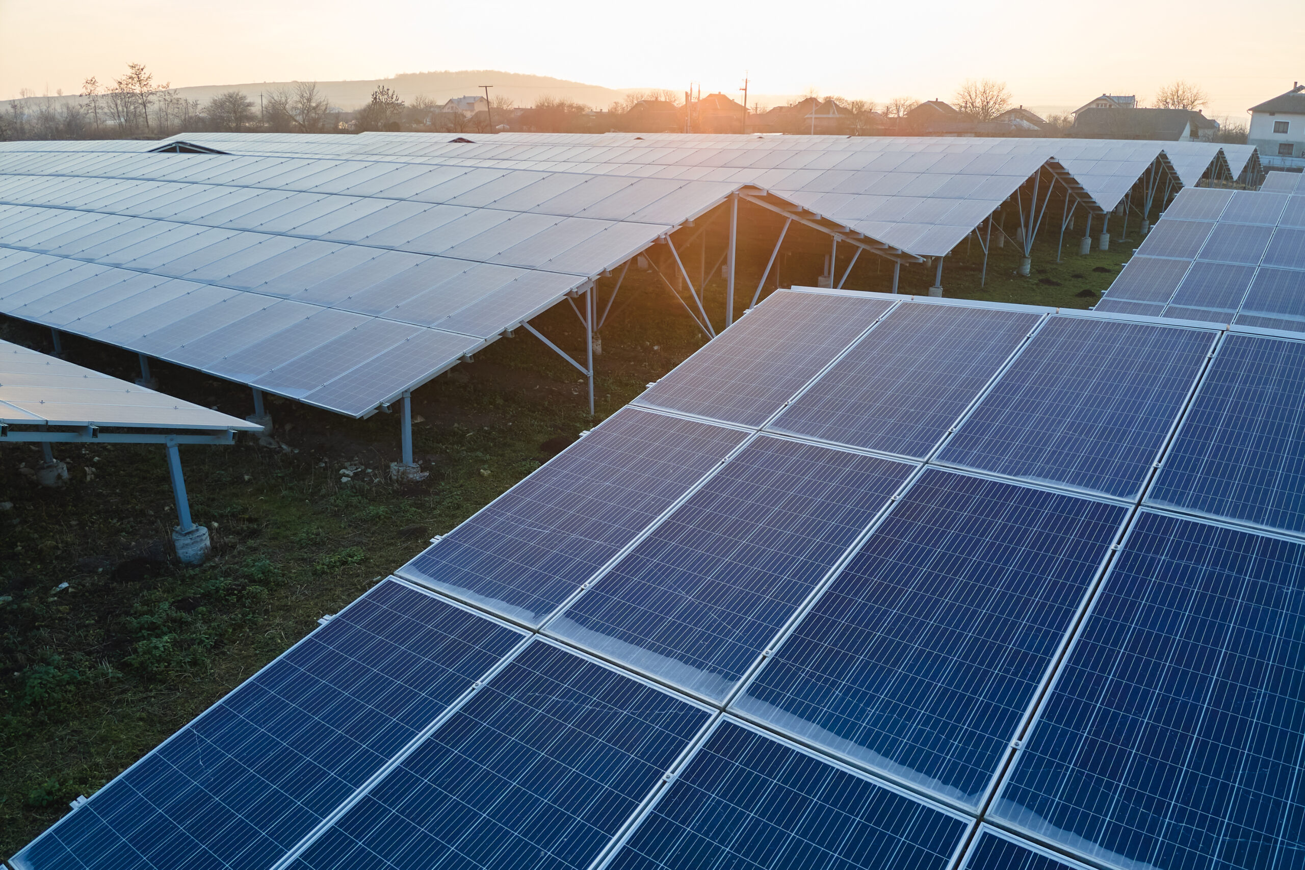 Aerial view of large sustainable electrical power plant with rows of solar photovoltaic panels for producing clean ecological electric energy. Renewable electricity with zero emission concept