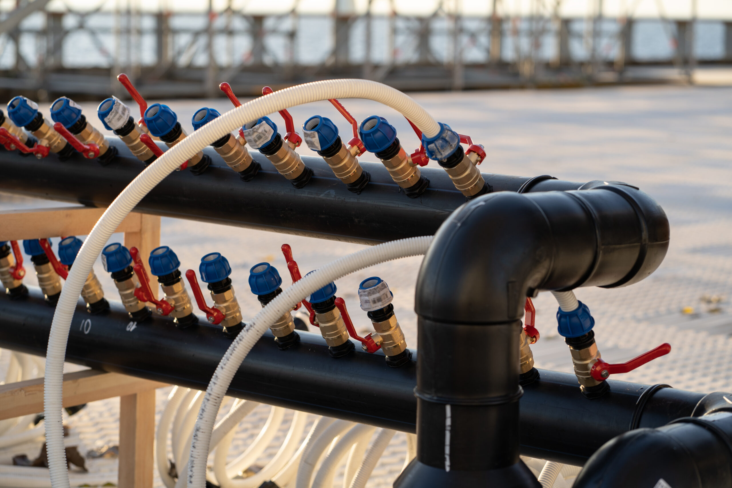 System of hoses and pipes for laying artificial skating rink. Modern contraction for maintenance of ice arena, skating rink or hockey field in city during winter holidays season. Outdoor activities