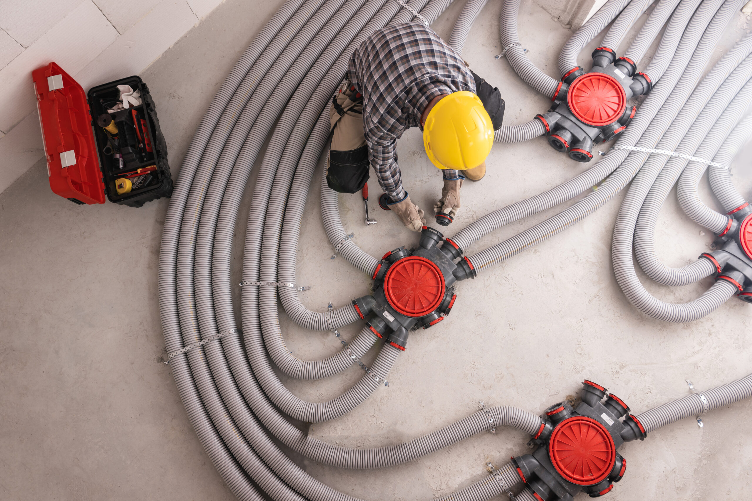 Modern Residential Heat Recuperation System Pipelines Installed by Professional Caucasian HVAC Technician in His 40s. Heat Ventilation Recovery Technology.